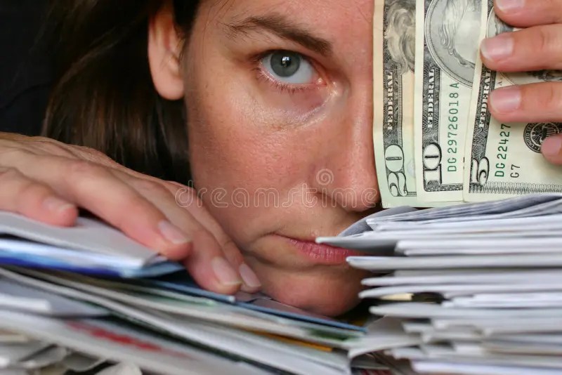 Worried Senior Woman Sitting On Sofa Looking At Bills Stock Image