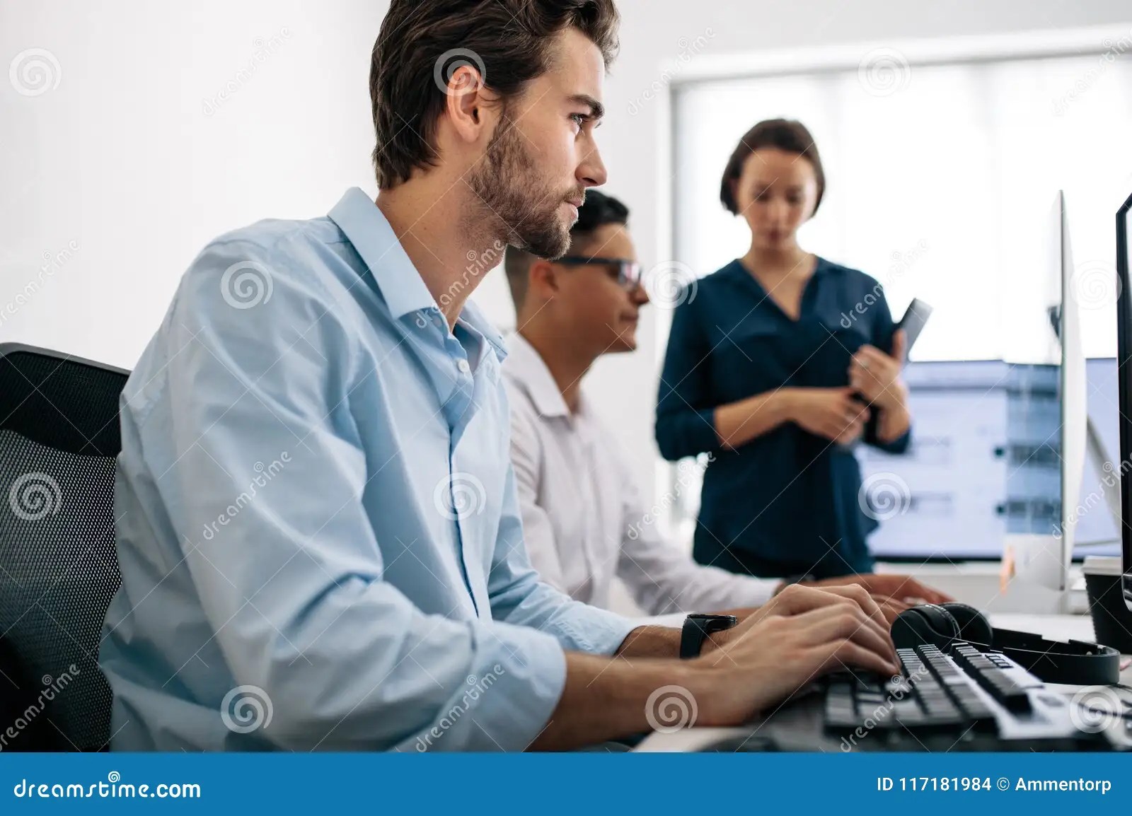 Application Developers Working On Computers In Office