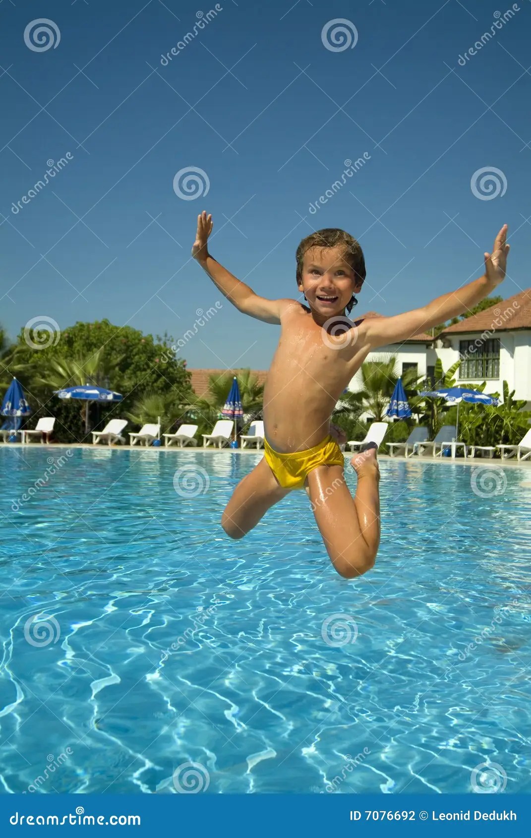 Boy jumping into the pool stock photo. Image of playful 7076692