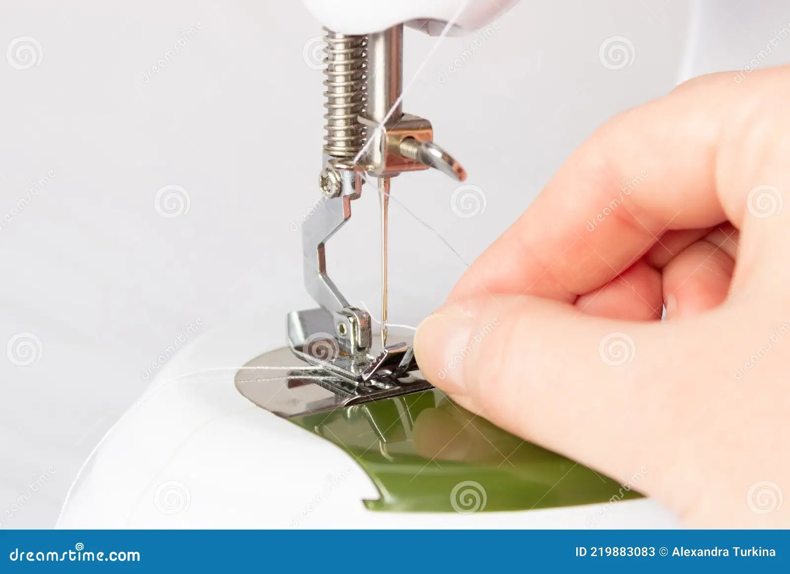 The Process of Threading the Thread into the Needle Eye of a Sewing