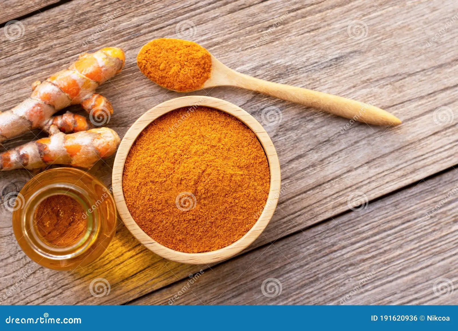 Tumeric Powder and Bottle of Turmeric Essential Oil Extracted Stock