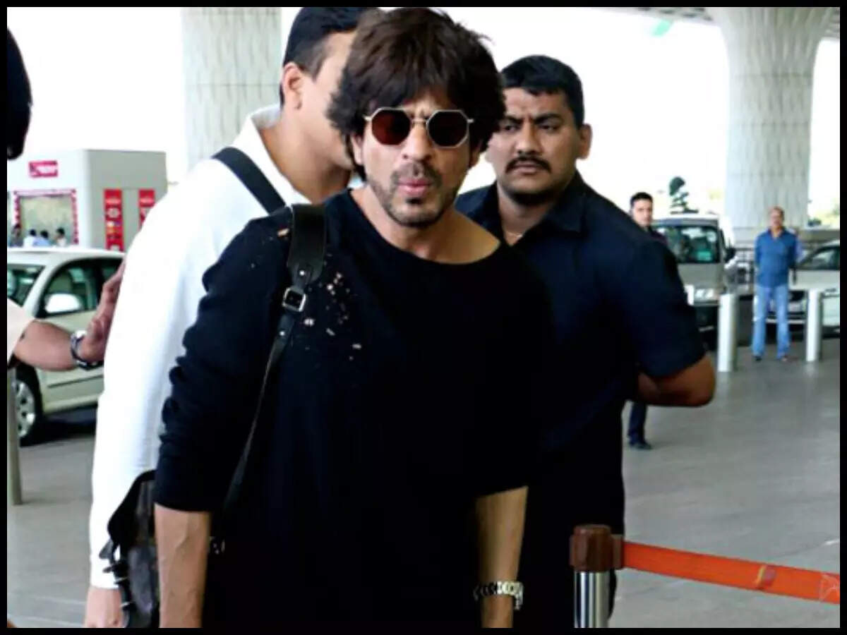 HOLLYWOOD & BOLLYWOOD LATEST NEWS Watch SRK hides under umbrella on arrival in city