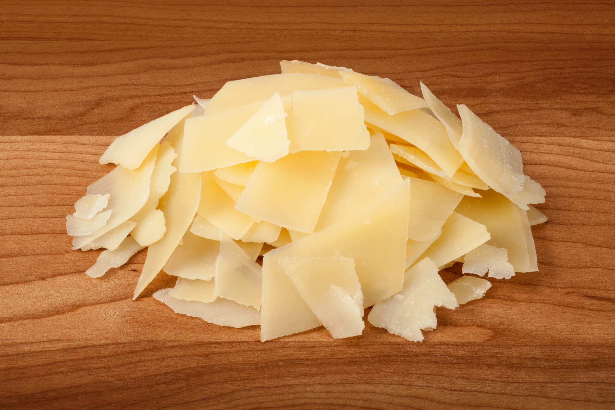 Shaved Parmesan Cheese on a wood cutting board Stock Photo Tony's