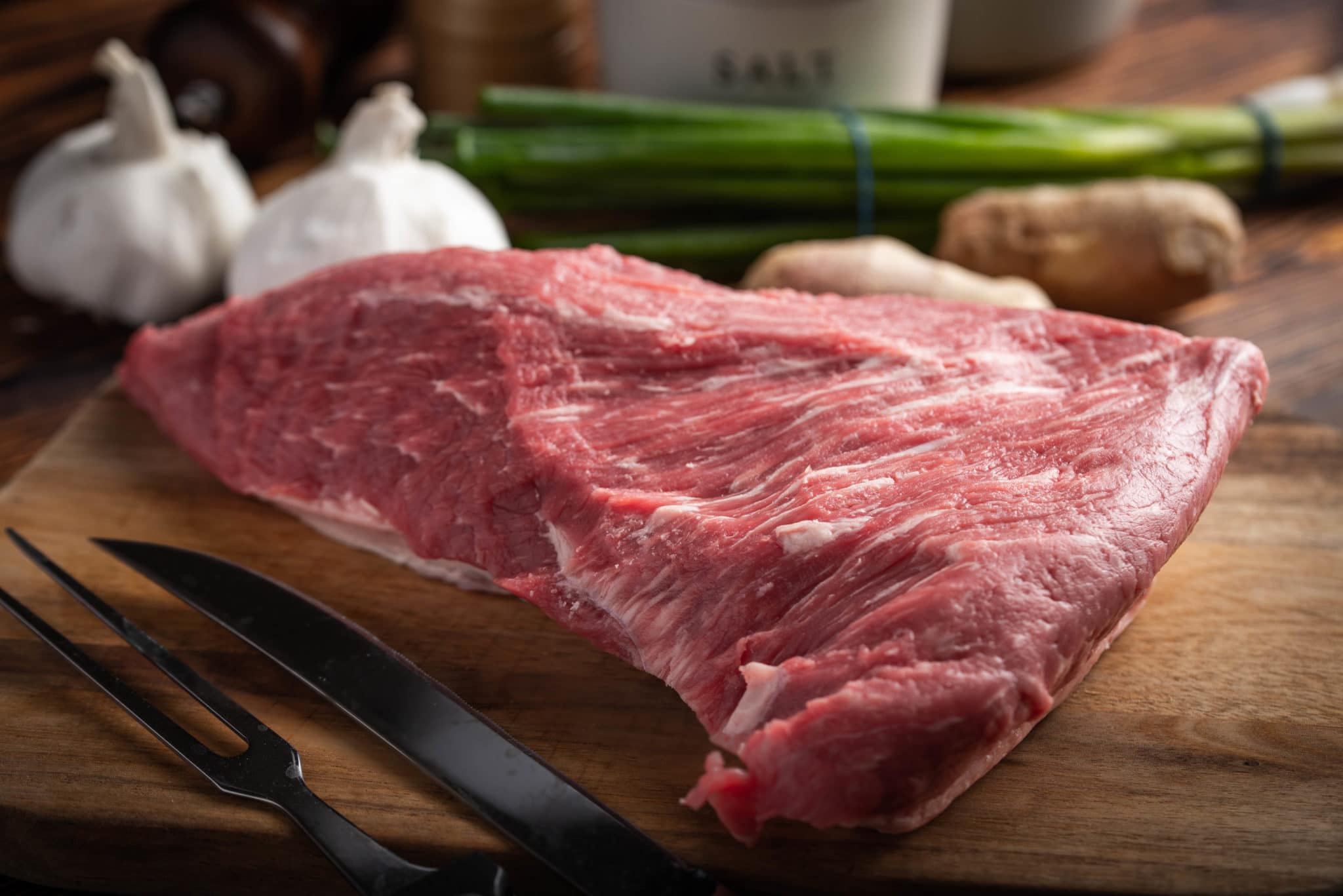raw tri tip steak beef on wooden cutting board Tony's Meats & Market