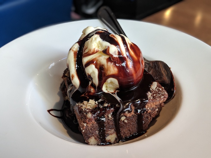 Warm Walnut Brownie ALa Mode topped with chocolate syrup and vanilla