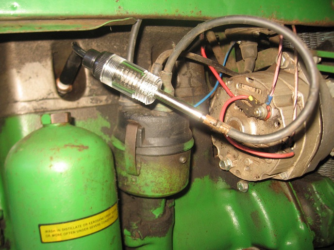How do you check a spark plug on a John Deere lawn mower?