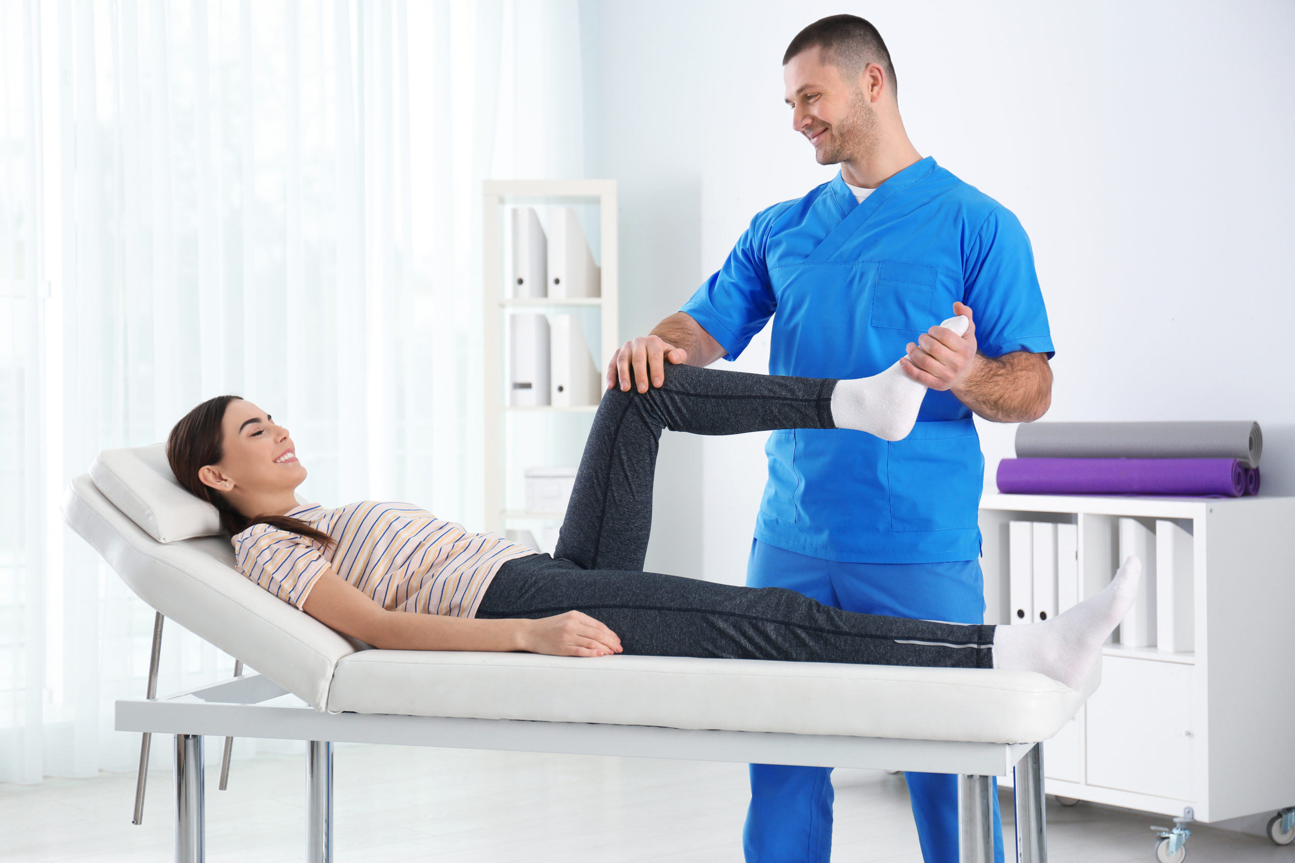 Doctor working with patient in hospital. Rehabilitation physiotherapy