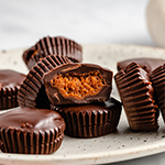 A speckled plate topped with many chocolate pumpkin butter cups.