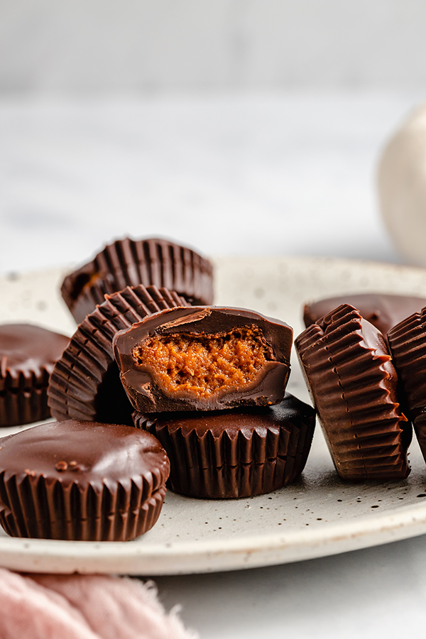 A speckled plate topped with many chocolate pumpkin butter cups.