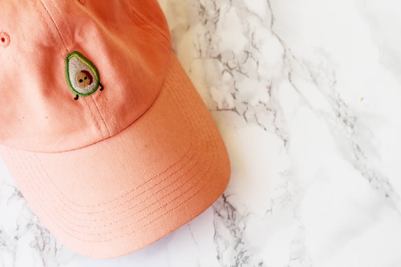 A orange hat with avocado on it.
