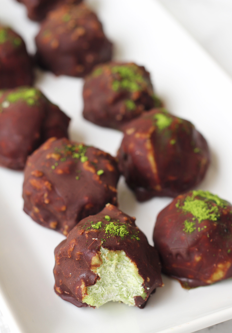 A row of chocolate matcha energy balls sitting on a platter.