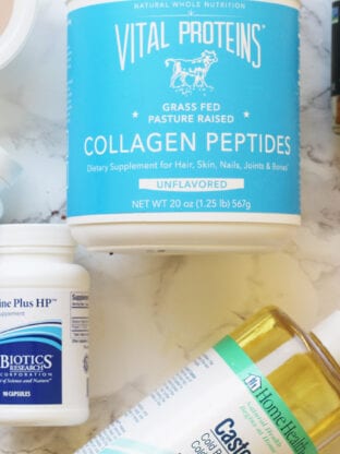 A collection of bottles of supplements on a counter including Vital Proteins Collagen Peptides.