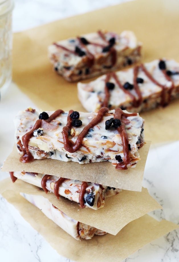 A few grain free granola bars on parchment paper and stacked with parchment paper between them.