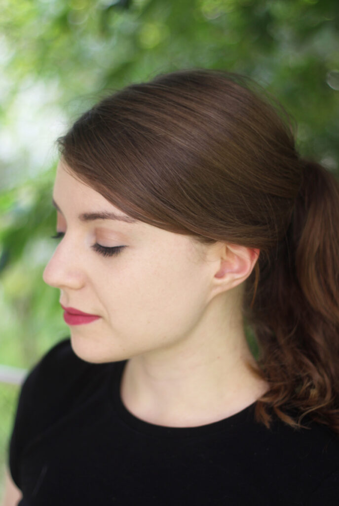 A photo of Michelle against a green background looking down.