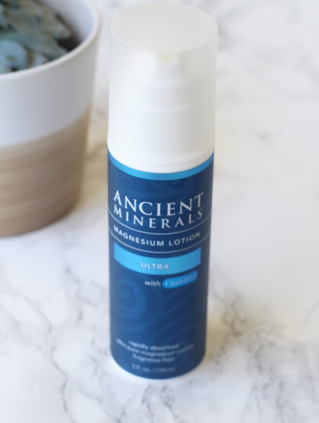 A bottle of Ancient Minerals Magnesium Lotion standing on a counter alone.