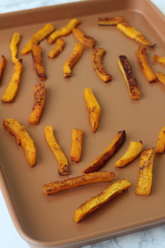 A sheet pan of butternut squash fries after being baked.