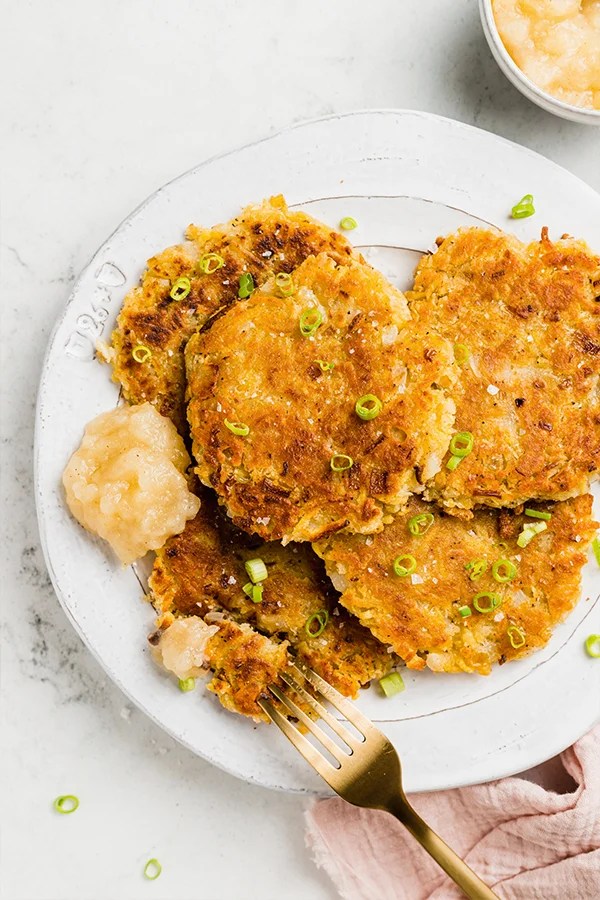 Fork on a plate with sweet potato latkes.