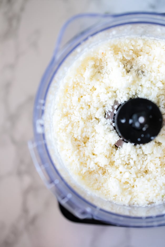 A open food processor filled with fresh cauliflower rice.