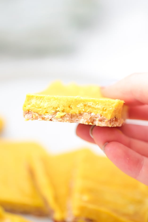 A hand holding a turmeric bar in it.