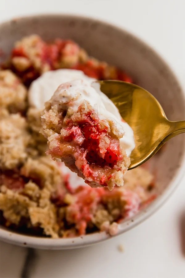 strawberry rhubarb crisp on a spoon.