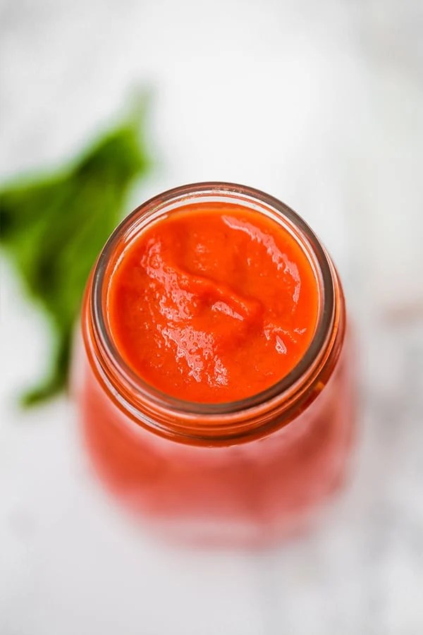 A view from above of glass jar filled with nightshade free marinara sauce.