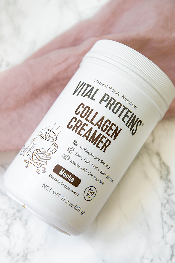 A canister of Vital Proteins Collagen Creamer in mocha flavor lying on a counter.
