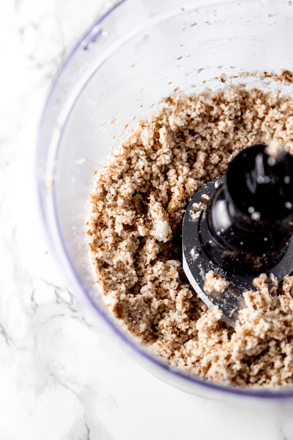 A food processor grinding up nuts in it.