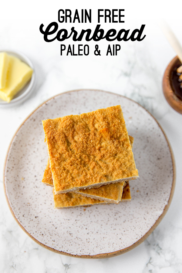 Grain free cornbread squares stacked on a plate with a side of butter and honey