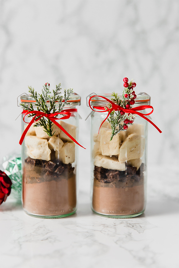 Two glass jars filled with DIY collagen hot cocoa mix and marshmallows with a bow around it.