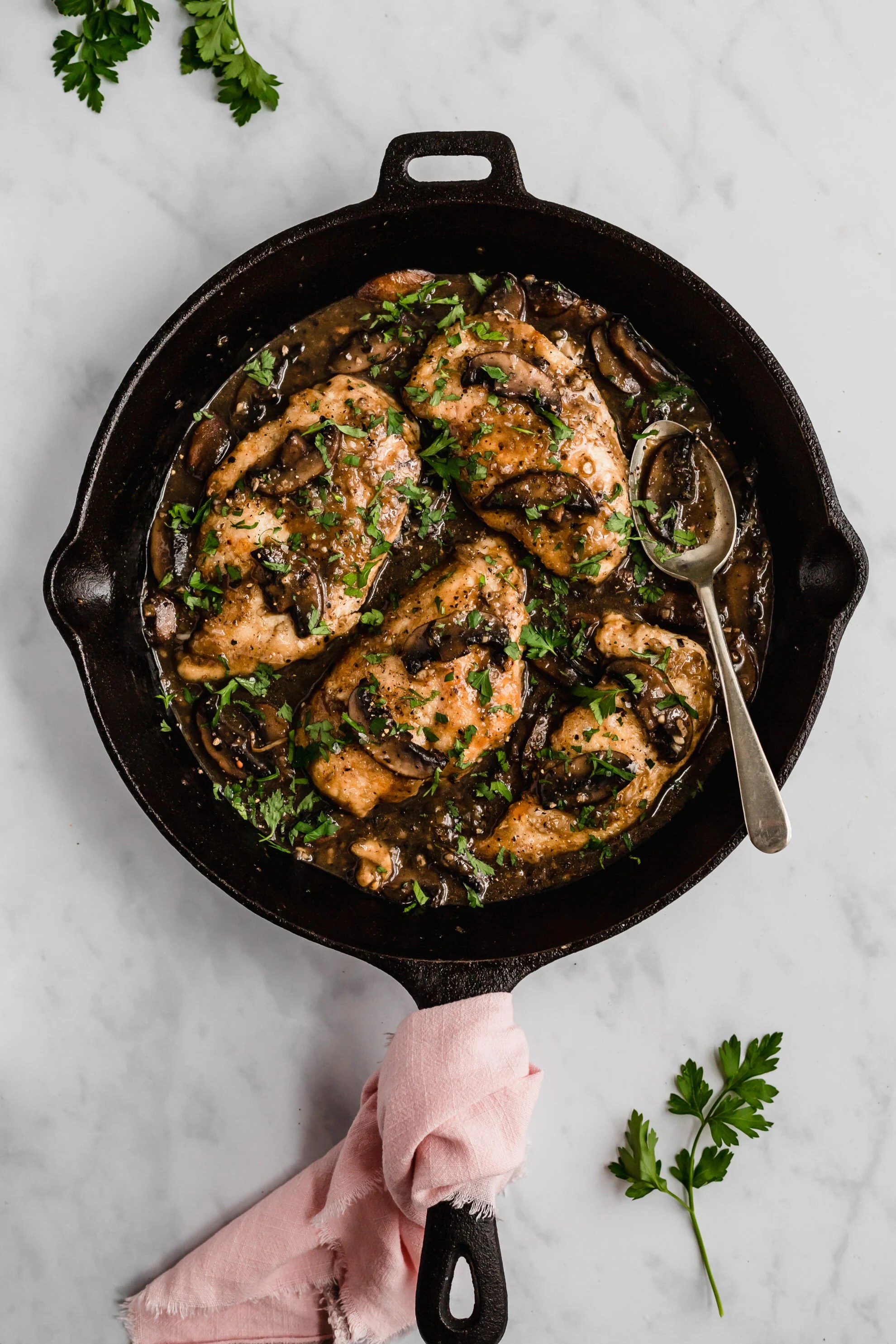A cast iron skillet filled with gluten free chicken marsala.