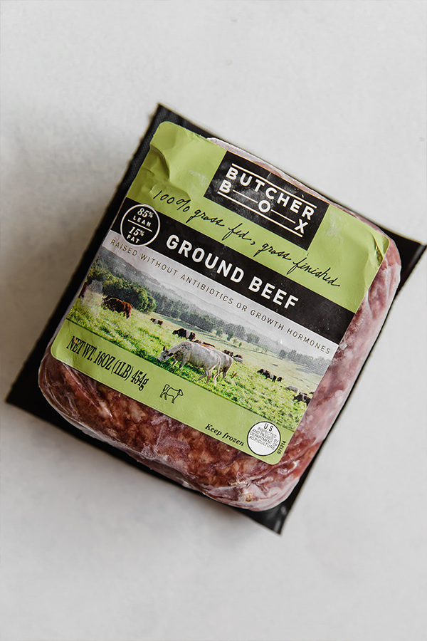 A package of frozen Butcher Box ground beef sitting out on a container.