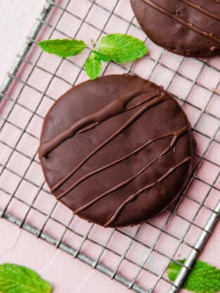 A paleo thin mint on a metal cooling rack with fresh mint next to it.