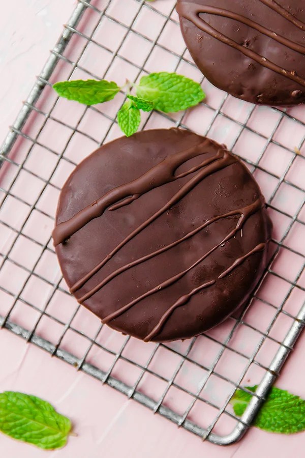 A paleo thin mint on a metal cooling rack with fresh mint next to it.