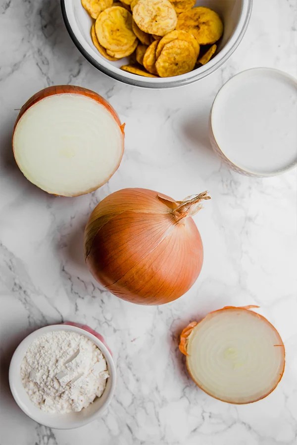 A few onions cut in a half and sitting on a counter.