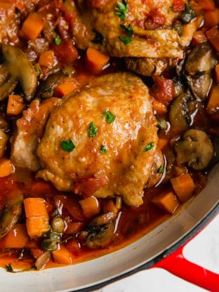 A cooking dish with chicken cacciatore in it after it finishes cooking.