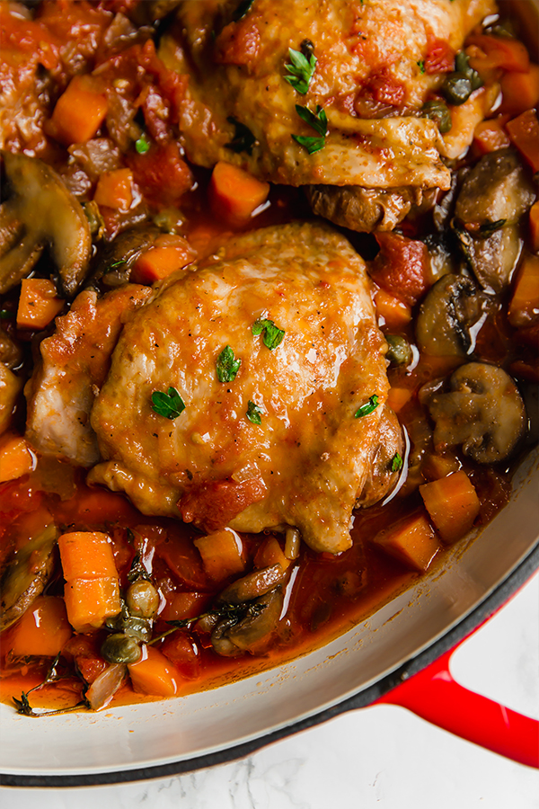 A cooking dish with chicken cacciatore in it after it finishes cooking.