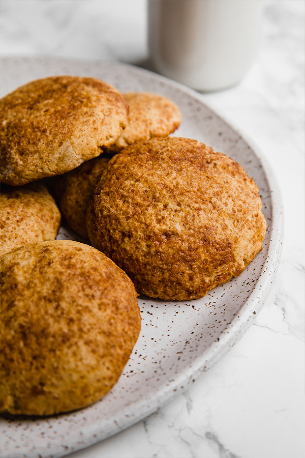 A white ceramic plate with pumpkin snickerdoodle cookies on it.