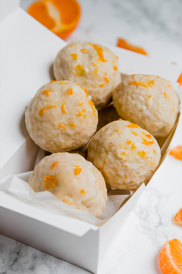 A white box filled with mandarin donut holes.