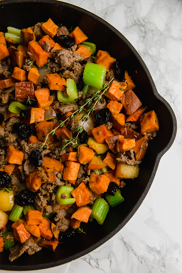 A cooking pan filled with paleo sweet potato sausage stuffing.