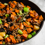 A cooking pan filled with paleo sweet potato sausage stuffing.