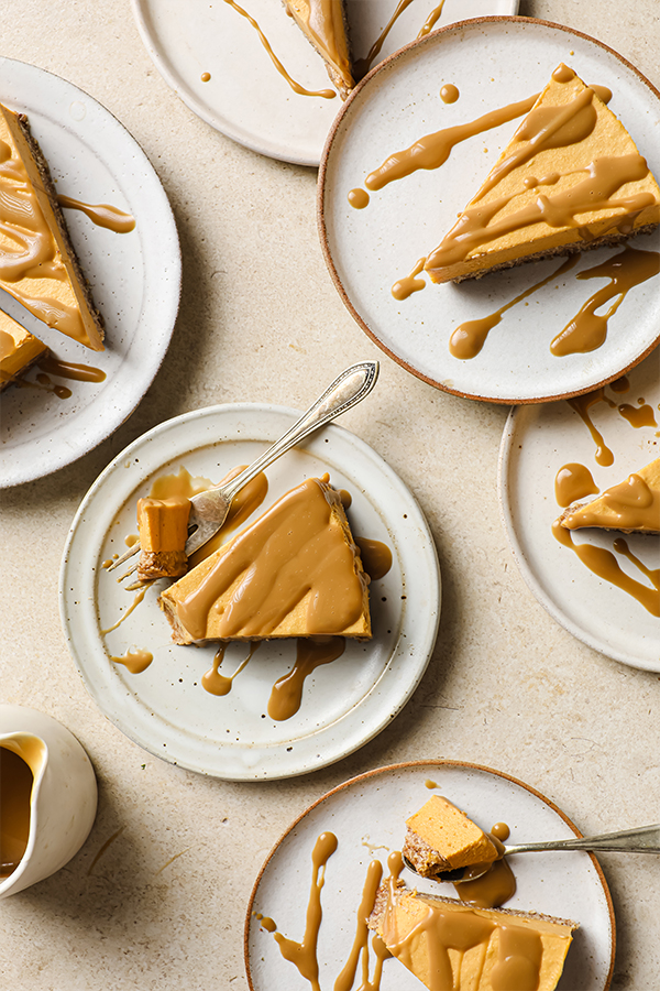 Several plates with slices of salted caramel pumpkin cheesecake.