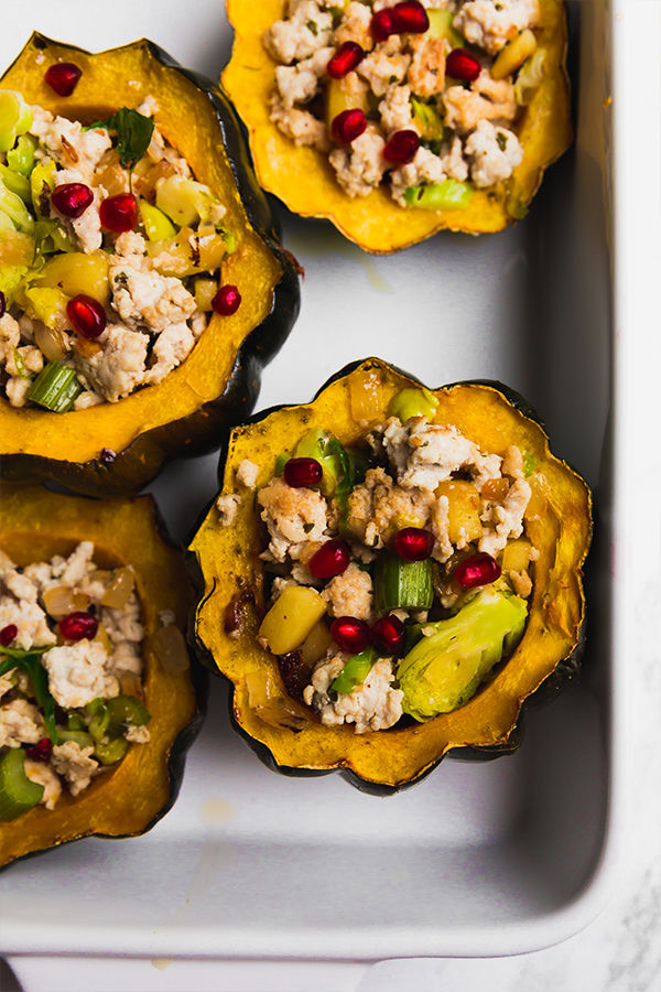 A baking dish with turkey stuffed acorn squashes after baking.