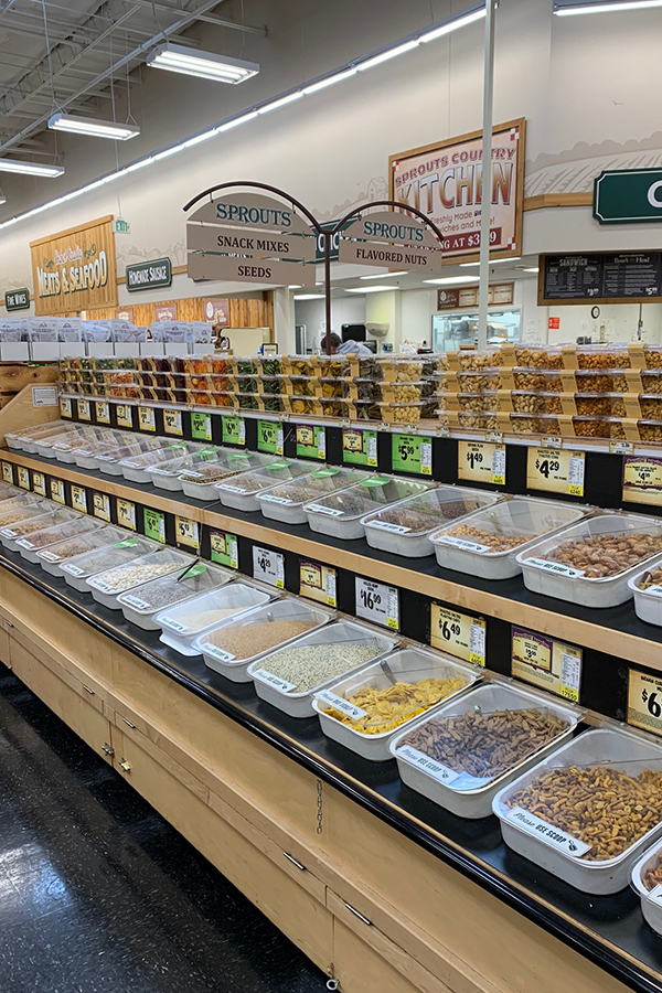 Bulk bins at the grocery store filled with nuts and other items.