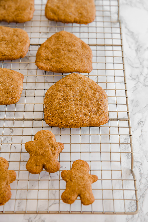 A wire rack with gingerbread cookies to make a gingerbread house cooling.
