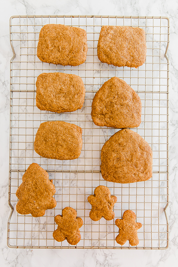 A wire rack with gingerbread cookies to make a gingerbread house cooling.