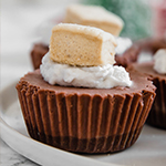 A white plate with hot cocoa cheesecakes on it.