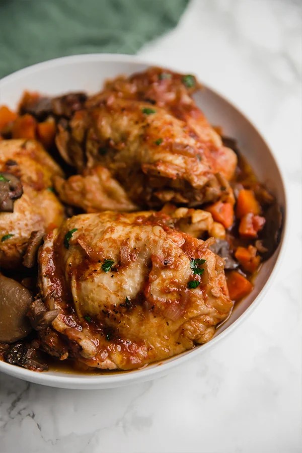 A serving bowl filled with slow cooker chicken cacciatore.