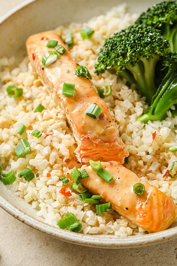 bang bang salmon in a bowl cut in half.