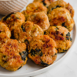 A white plate filled with spinach & artichoke chicken poppers.