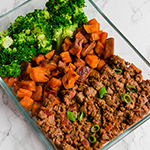 A glass meal prep container filled with carrots, sweet potatoes and sloppy joes.